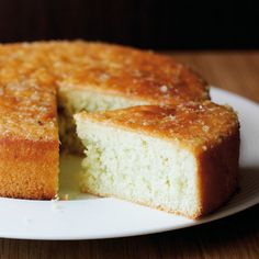 a white plate topped with a cake cut in half on top of a wooden table