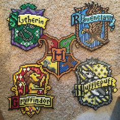 four different hogwart badges are on the carpet