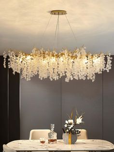 a dining room table with chairs and a chandelier hanging from it's ceiling