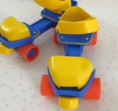 three yellow and blue toy cars sitting on top of a white tablecloth covered floor