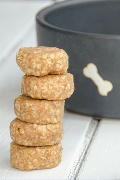 four oatmeal cookies stacked on top of each other in front of a bowl