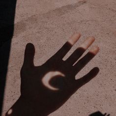 a hand casting a shadow on the ground