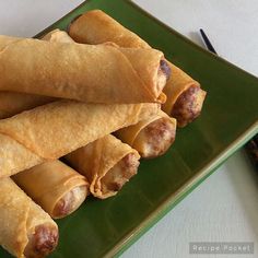 some food is sitting on a green plate and ready to be eaten with chopsticks