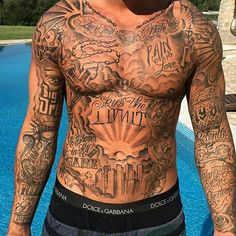 a man with lots of tattoos on his chest standing next to a swimming pool and looking at the camera