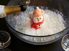 a glass bowl filled with bubbles and a snowman figurine in the middle