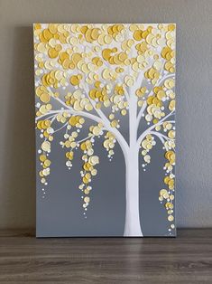 a painting with yellow and white circles hanging on the wall next to a wooden table