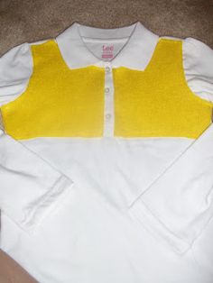 a yellow and white shirt sitting on top of a floor