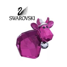 a pink cow is standing next to the swaroskii logo