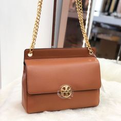 Tory Burch Shoilder Bag From The Chelsea Collection Crafted In Pebbled Leather With Gold-Tone Metal Hardware. This Shoulder Bag Features 1 Main Pocket, Zip Pocket, Flap With A Magnetic Snap Closure, And A Adjustable Leather/Chain Strap With A 19.92" Drop. Dimensions: H: 9.16" X L: 10.56". Cognac Flap Shoulder Bag With Gold-tone Hardware, Pebbled Leather Bags With Gold-tone Hardware For Everyday Luxury, Pebbled Leather Bag With Gold-tone Hardware, Leather Tote Flap Bag With Branded Hardware, Leather Flap Tote Bag With Branded Hardware, High-end Brown Shoulder Bag With Gold-tone Hardware, Brown Shoulder Bag For Everyday Luxury, Elegant Brown Flap Bag With Branded Hardware, Luxury Brown Textured Leather Flap Bag