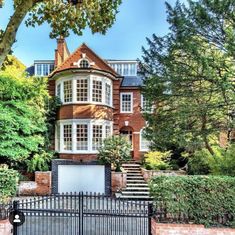 a large brick house with an iron gate