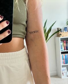 a woman's arm with the word hwy on it and a small tattoo