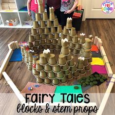 two children standing in front of a tower made out of cups