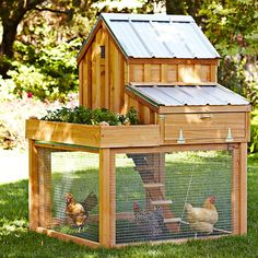 a chicken coop with two chickens in it and a small house on the top floor