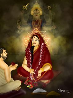 a man kneeling down next to a woman in a red sari sitting on the ground