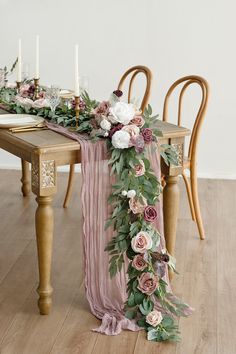 the table is decorated with flowers and greenery for an elegant touch to the dining room