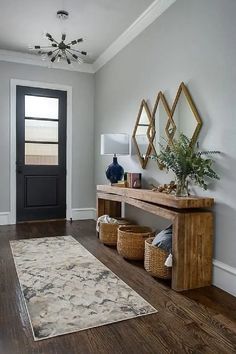 a room with a rug, table and two mirrors on the wall next to it