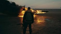 a man standing in front of an airplane on fire