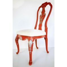 an antique red chair with white upholstered seat