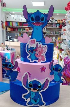 three tiered cake decorated with cartoon characters on it's sides in a store