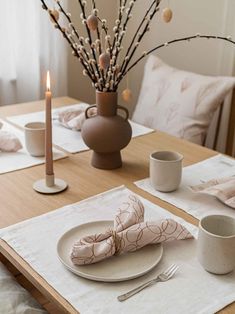 the table is set with dishes, cups and napkins