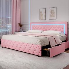 a pink bed with an illuminated headboard and foot board is in a white room