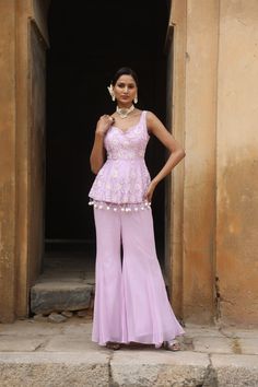 Featuring Lilac silk peplum with sequence, beads floral motif embroidery on bodice, paired with georgette inserted sharara. Fabric - Silk and Georgette Components - 2 Colour - Lilac Embroidery details - Hand Embroidery Delivery time - 2-3 weeks Washing Instructions - Dry-clean Elegant Peplum Set In Georgette, Elegant Georgette Peplum Set, Fitted Sharara With Pearl Embroidery For Designer Wear, Fitted Pearl Embroidery Sharara For Designer Wear, Party Wear Georgette Sharara With Floral Embroidery, Wedding Peplum Set With Intricate Embroidery, Wedding Sets With Intricate Embroidery And Peplum Shape, Fitted Embellished Peplum Palazzo Set, Embellished Fitted Peplum Palazzo Set