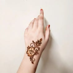 a woman's hand with henna tattoo on her left wrist and the words henna mehna written in arabic