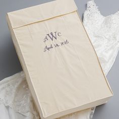 the wedding dress is laying next to an open box on top of lace and fabric