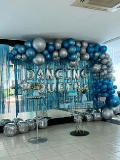 a room filled with blue and silver balloons