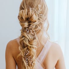 the back of a woman's head wearing a hair comb with pearls on it