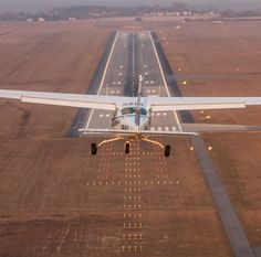 an airplane is taking off from the runway at sunset or dawn, with lights on it's wings