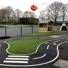 a play area with artificial grass and playground equipment