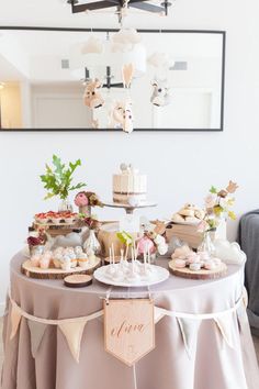 a table topped with cakes and desserts under a mirror