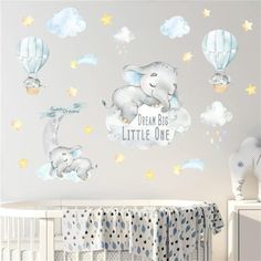 a baby's nursery room with an elephant and hot air balloons on the wall