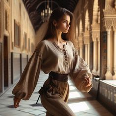 a woman standing in an old building with her arms spread out and looking off into the distance