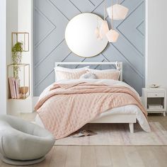 a white bed sitting in a bedroom next to a round mirror on the side of a wall