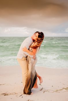 a man and woman kissing on the beach