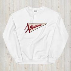 Show off your Southern pride with our Vintage Alabama Pennant Flag Crewneck Sweatshirt, a perfect blend of retro style and modern comfort. Featuring a vintage-style pennant flag graphic that proudly says "Alabama," this sweatshirt is ideal for anyone who loves classic designs with a timeless feel. Made from soft, high-quality fabric, this crewneck is perfect for layering on cooler days or wearing solo to showcase your Alabama spirit. Whether you're a Crimson Tide fan, an Alabama native, or simply love the nostalgic look of vintage pennants, this sweatshirt is a stylish way to celebrate your love for the state. With its unisex fit and versatile design, this Alabama pennant sweatshirt is perfect for casual outings, gamedays, or as a thoughtful gift for anyone who cherishes the Heart of Dixie Retro Cotton Pre-shrunk Sweatshirt, Retro Fan Gear Sweatshirt For Sports Season, Vintage Cotton Sweatshirt For Sports Events, Retro Sweatshirt For Sports Events, Retro White Sweatshirt For College, Cotton Crew Neck Sweatshirt With Flag Print, Pennant Sweatshirt, Alabama Sweatshirt, Crimson Tide Fans