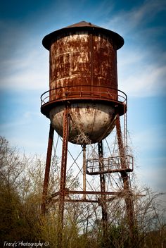 an old rusted water tower in the middle of nowhere