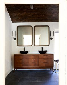 an instagram page with two sinks and mirrors on the wall, one is dark wood