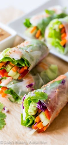 two rolls filled with veggies on top of a cutting board