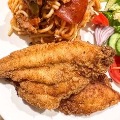 a white plate topped with pasta and meat next to a side of veggies