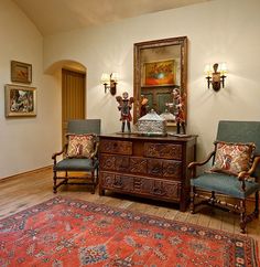 a living room with two chairs and a dresser