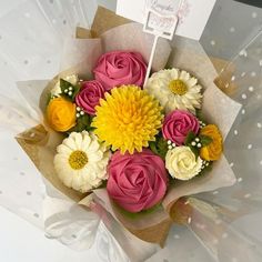 a bouquet of colorful flowers sitting on top of a white table next to a card