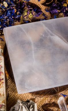 a piece of ice sitting on top of a wooden table next to other items and flowers