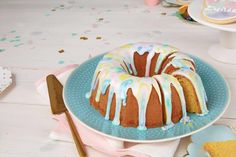 a bundt cake with icing and sprinkles on a blue plate