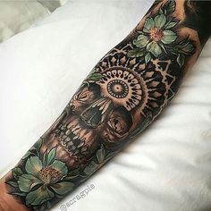 a person with a tattoo on their arm that is decorated with flowers and an elephant