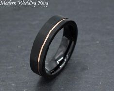 a black and gold wedding ring on a table