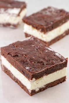 three pieces of chocolate and white dessert sitting next to each other