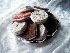 several crocheted donuts are sitting on a doily with silver foil in the background